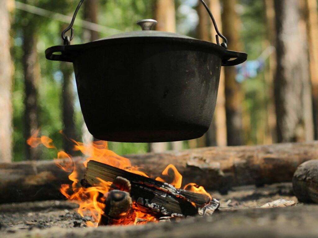 black cooking pot on burning wood